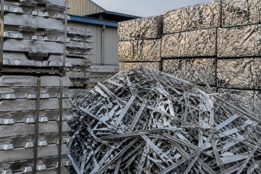 Aluminium ingots and compacted aluminium scrap bales in a metals yard