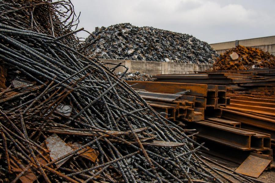 Ferrous scrap metal including steel rebar and structural beams in a recycling yard